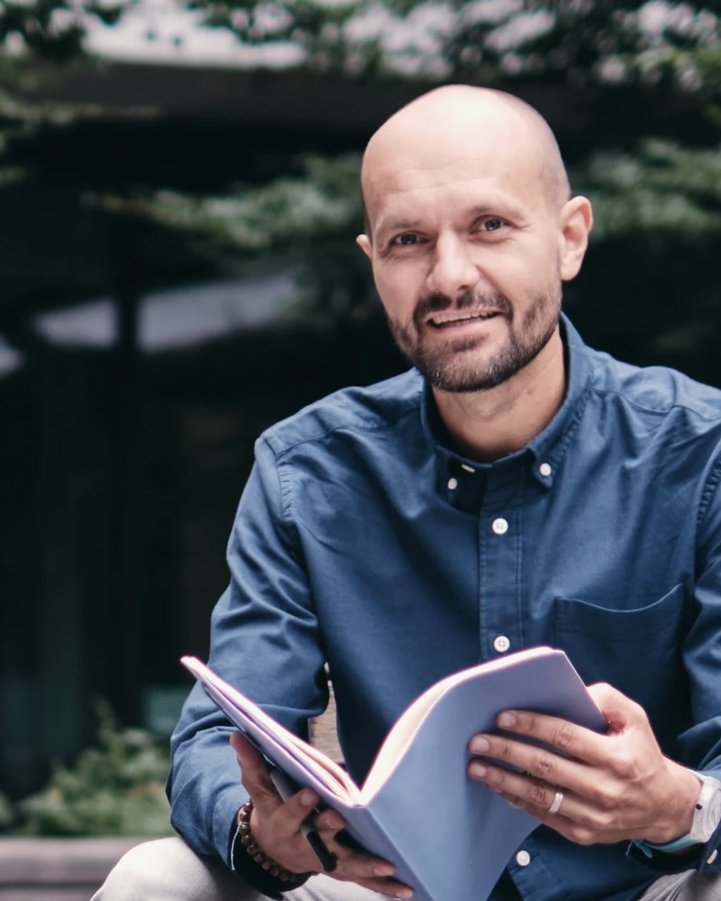 Martin Angehrn im Freien mit einem Notizbuch